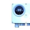 Blue rectangular device with a round digital display and control buttons, likely a thermostat or controller, mounted on equipment.